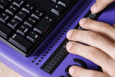 Fingers typing on a braille keyboard